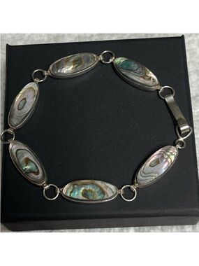 Sterling silver bracelet with iridescent abalone shell inlays.